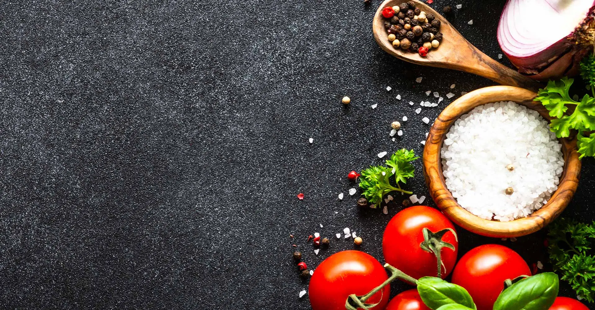 Frische Kräuter, Tomaten und Gewürze auf dunklem Untergrund